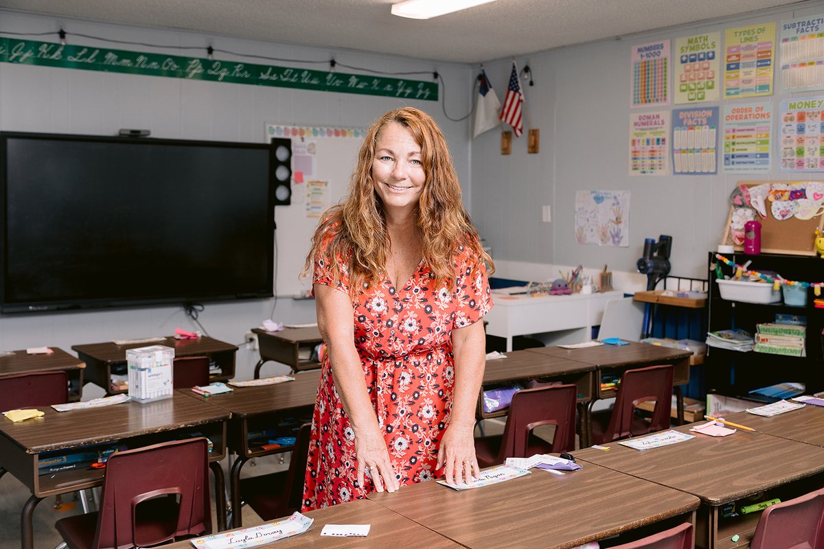 Nancy Bostock helping students with classwork at their desks