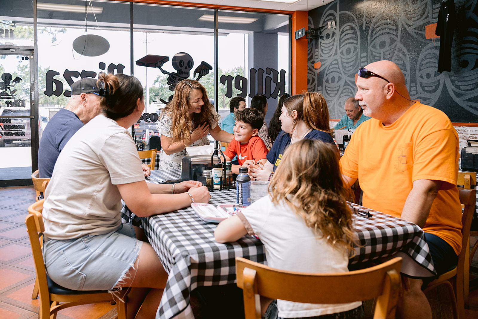 Nancy Bostock greeting a family at a local restaurant
